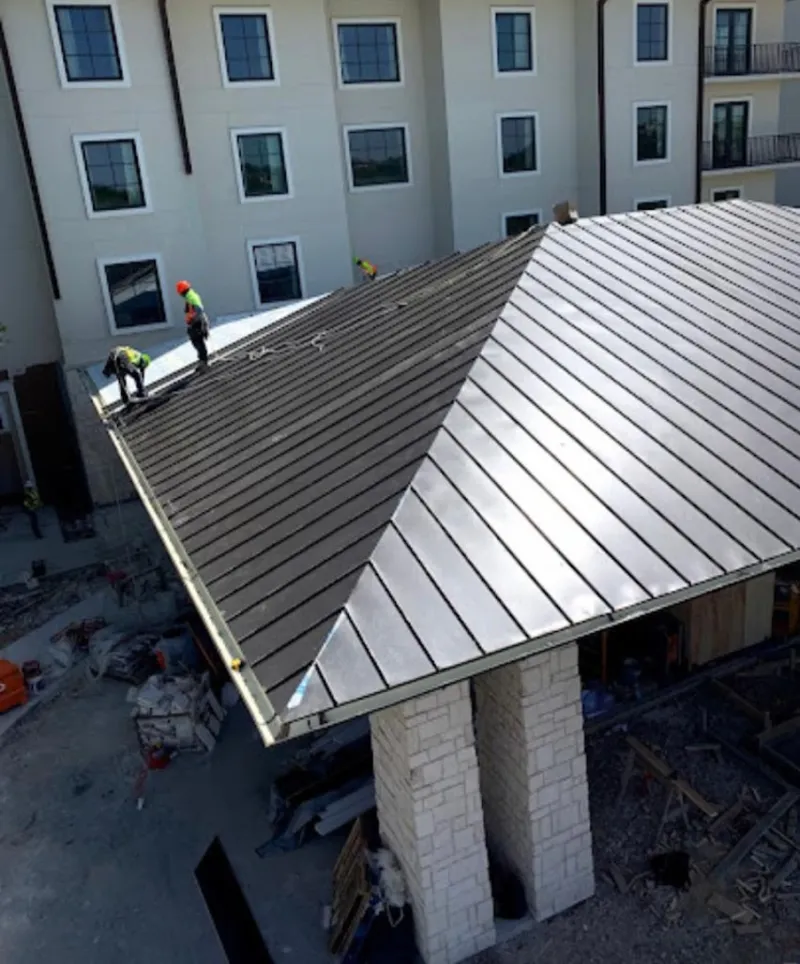Crew installing standing seam metal roof panels on a commercial project in Boonton